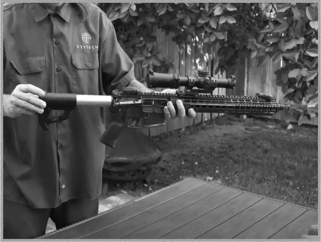 A person holds a sleek firearm with a mounted scope, showcasing a detachable stock, demonstrating firearm customization.